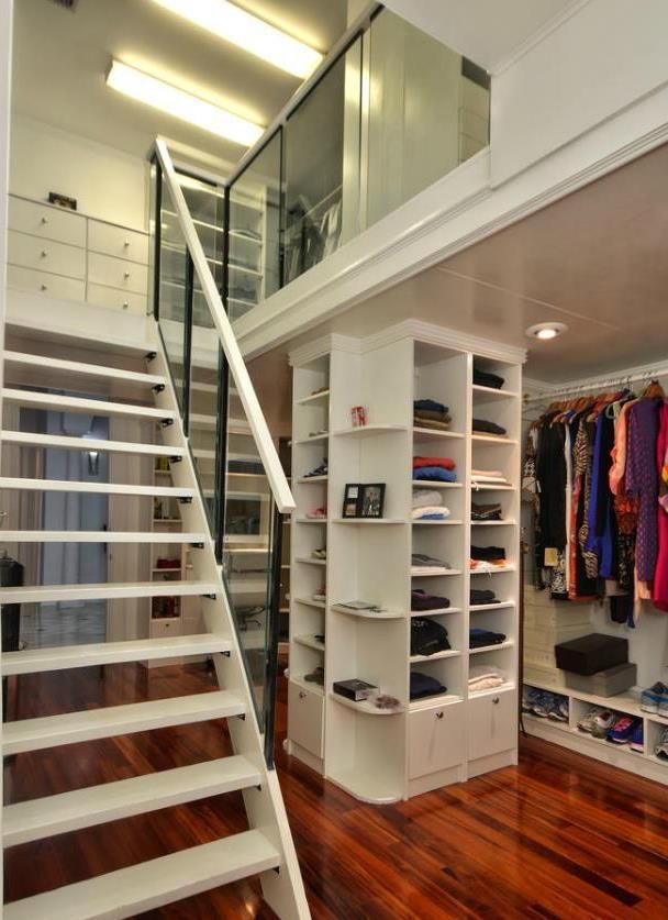 Beautiful two story closet with wood floors and plenty of shelves and